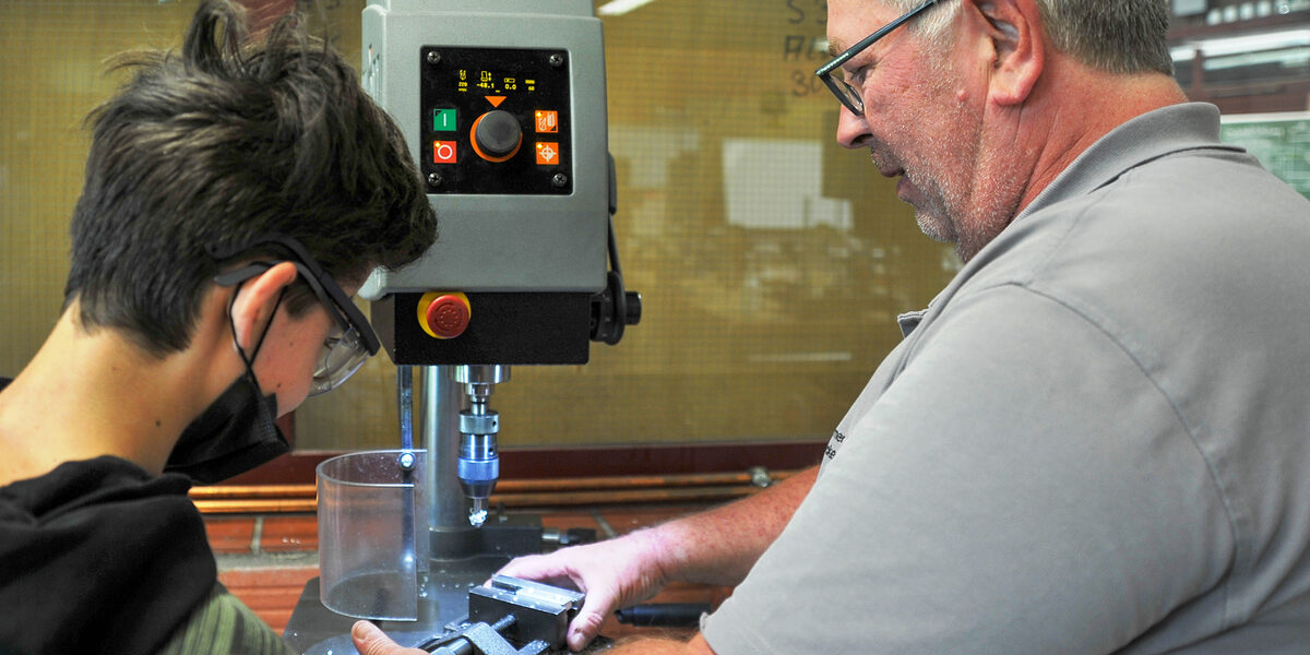 Präzision gefragt: An der Senkmaschine in der Metallwerkstatt zeigt Ausbildungsmeister Michael Becker, wie man Material durch Zerspanung in die richtige Form bringt. Präzision gefragt: An der Senkmaschine in der Metallwerkstatt zeigt Ausbildungsmeister Michael Becker, wie man Material durch Zerspanung in die richtige Form bringt.