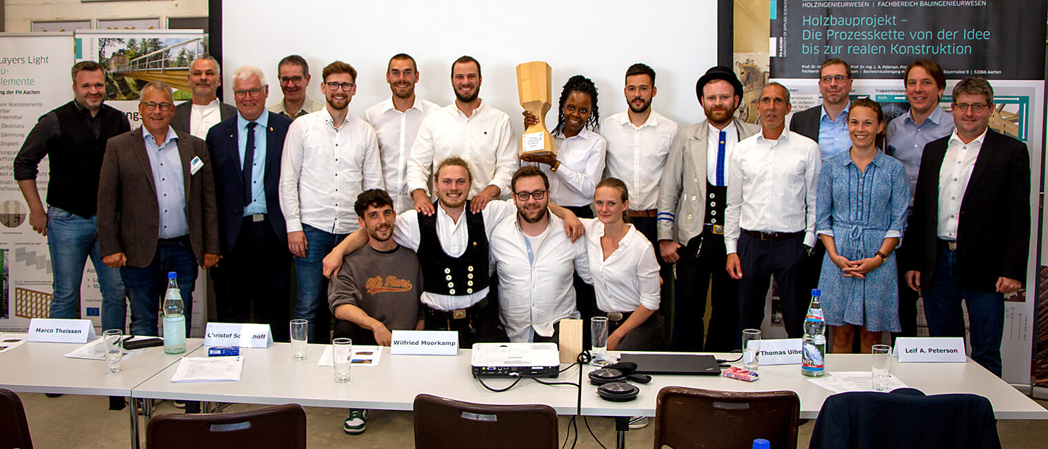 Jurymitglieder, Organisatoren, Gewinnerinnen und Gewinner mit Pokal und Holzhütte.
