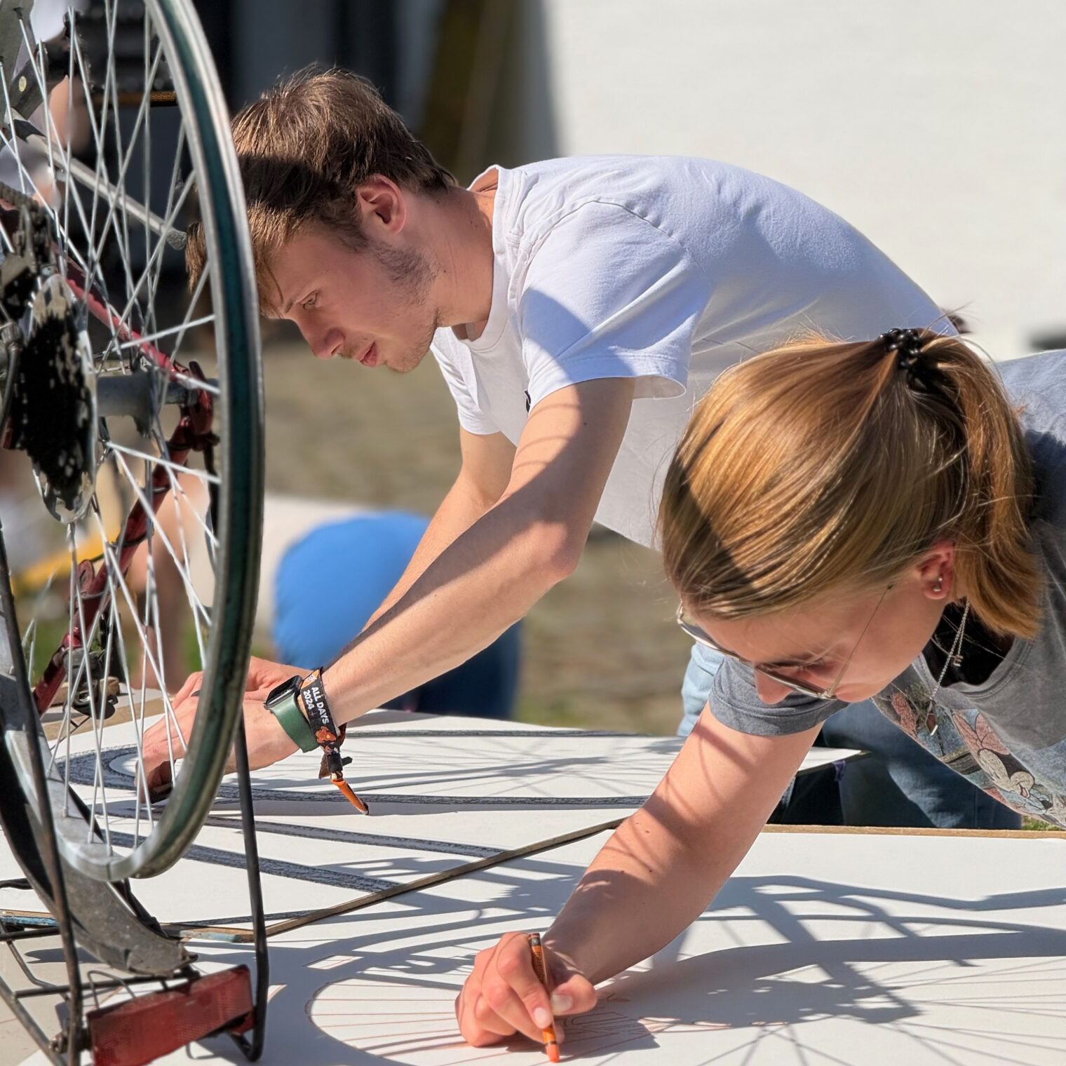 Student der Akademie für Handwerksdesign Gut Rosenberg der Handwerkskammer Aachen zeichnen den Schatten eines Rades nach.