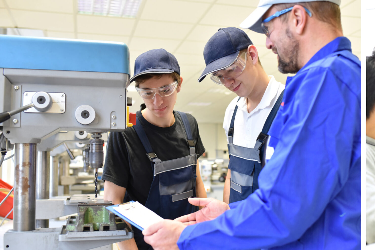 Jugendliche im Praktikum arbeiten mit einer Bohrmaschine und die andere Gruppe testet Schaltkreise
