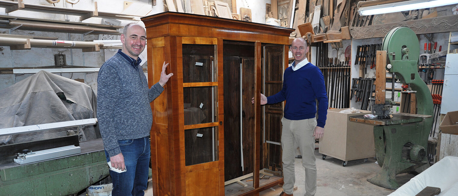 Kostbarer Schrank, von Meisterhand restauriert: Marcus Schiffers (l.) und Marco Herwartz vor dem mit Schellack überzogenen Familienstück. Foto: Elmar Brandt Kostbarer Schrank, von Meisterhand restauriert: Marcus Schiffers (l.) und Marco Herwartz vor dem mit Schellack überzogenen Familienstück. Foto: Elmar Brandt